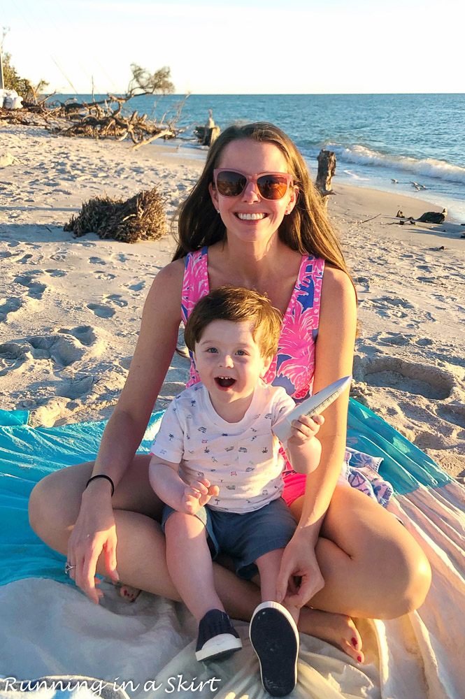 Mom holding child on the beach in Sanibel. sharing the places to eat on Sanibel.