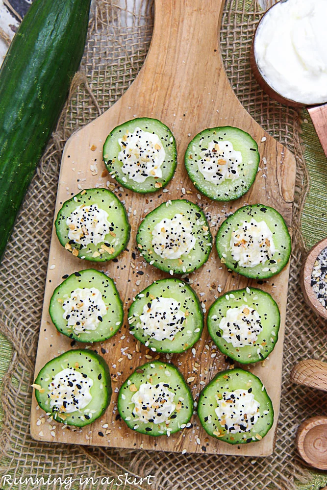Overhead shot of the cucumber snacks on a wooden cutting board.