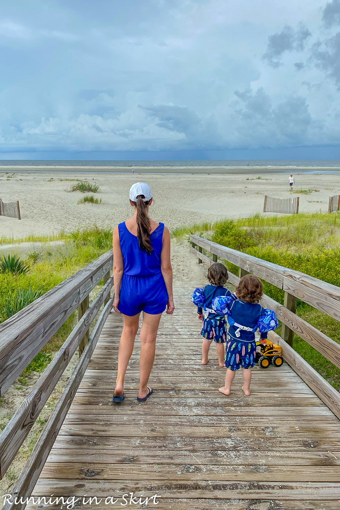 Mom walking with toddlers to the beach.